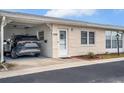 Front view of a light-colored, single-story home with carport and landscaping at 12400 Park Blvd # 206, Seminole, FL 33772