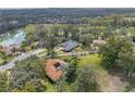 Aerial view of a single Gathering home nestled in a quiet community with a lake nearby at 12632 Oak Hollow Ct, Dade City, FL 33525