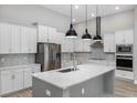 Modern kitchen with white cabinets, quartz island, and stainless steel appliances at 13458 Haflinger Way, Hudson, FL 34667