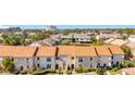 Condo building with tan exterior, brown roof and lush landscaping, aerial view at 13600 Egret Blvd # 204K, Clearwater, FL 33762