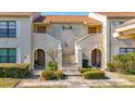 Condo building exterior, featuring two units with arched entryways and landscaping at 13600 Egret Blvd # 204K, Clearwater, FL 33762
