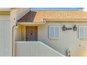 Condo unit entrance with brown door, white shutters, and exterior light fixture at 13600 Egret Blvd # 204K, Clearwater, FL 33762