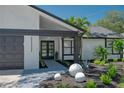 Modern front entrance with dark gray double doors, gray brick walkway and white walls at 14040 Cascade Ln, Tampa, FL 33618