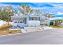 Front view of a white mobile home with carport, showing landscaping at 27466 Us Highway 19 N # 78, Clearwater, FL 33761