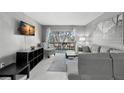 Bright living room with gray sectional sofa and access to balcony at 3245 Beneva Rd # 201, Sarasota, FL 34232
