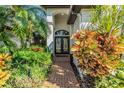 Elegant front entrance with double doors, brick walkway, and tropical plants at 335 Palmdale Dr, Oldsmar, FL 34677