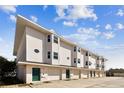 Modern three-story building with garages and green doors at 3629 Gulf Blvd, St Pete Beach, FL 33706