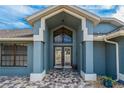 Front entrance with double doors and a decorative light fixture at 5052 Florentine Ct, Spring Hill, FL 34608