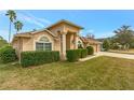 Tan house with three-car garage and manicured hedges, daytime view at 10025 Cypress Shadow Ave, Tampa, FL 33647