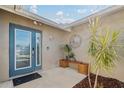 Inviting entryway with a teal door, decorative wall art, and potted plants at 10079 83Rd Way, Seminole, FL 33777