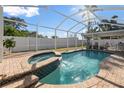 Relaxing screened-in pool and spa area with patio furniture at 10079 83Rd Way, Seminole, FL 33777