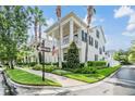 Corner lot showing a two-story home with a columned porch, balcony, an American flag, and manicured landscaping at 10444 Green Links Dr, Tampa, FL 33626