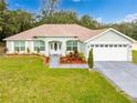House exterior with a well-maintained lawn and attached garage at 11421 Petrel Ave, Weeki Wachee, FL 34614