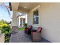 Relaxing front porch with wicker chairs and red patterned cushions at 15720 Buckford Landing Pl, Sun City Center, FL 33573