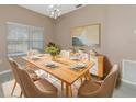 Modern dining room with a light wood table and neutral decor at 3404 Shady Brook Ln, Sarasota, FL 34243