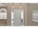 Bright entryway with a white door, neutral walls, and light fixtures at 3404 Shady Brook Ln, Sarasota, FL 34243