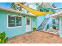 Private patio with brick flooring and yellow shade sail at 604 Pennsylvania Ave, Crystal Beach, FL 34681