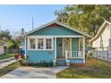 Charming turquoise home with a welcoming front porch and well-maintained landscaping at 612 12Th S Ave, St Petersburg, FL 33701