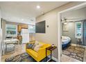 Cozy living room features tile flooring, a bright yellow couch and an open doorway to the bedroom and kitchen at 612 12Th S Ave, St Petersburg, FL 33701