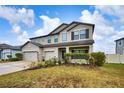 Two-story house with a gray exterior, landscaped lawn, and two-car garage at 8044 Lago Mist Way, Wesley Chapel, FL 33545