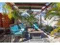 Relaxing patio with fire pit, seating area, and lush tropical landscaping at 10941 Oakdale Ave, Port Richey, FL 34668