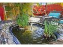 Tranquil backyard pond with a small fountain, surrounded by lush greenery at 10941 Oakdale Ave, Port Richey, FL 34668
