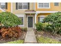 Townhome entrance with gray door and neatly landscaped walkway at 1308 Costa Mesa Dr, Wesley Chapel, FL 33543