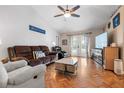 Bright living room with hardwood floors, comfy seating, and a large TV at 13215 Parkhurst Ct, Riverview, FL 33569
