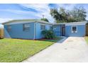 Newly painted light blue home with a spacious yard and driveway at 2009 Windsor Way, Tampa, FL 33619