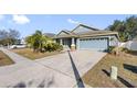 Exterior view showcasing a house with a gray exterior, landscaping, and a driveway at 24745 Portofino Dr, Lutz, FL 33559