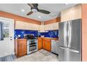 Modern kitchen featuring stainless steel appliances and bright blue backsplash tiles at 2619 Miriam S St, Gulfport, FL 33711