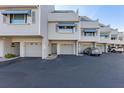 Exterior view of townhome featuring private garages, neutral siding, and well-maintained landscaping at 380 Pinellas Bayway S. # E, Tierra Verde, FL 33715