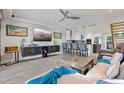 Open-concept living area with sleek gray tile floors, stylish furniture, and an island with bar stool seating at 380 Pinellas Bayway S. # E, Tierra Verde, FL 33715
