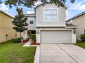 Two-story house with a two-car garage and landscaped front yard at 7440 Dragon Fly Loop, Gibsonton, FL 33534