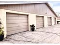 Four-car garage with light brown doors and landscaping at 1000 Dunrobin Dr # C, Palm Harbor, FL 34684