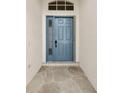 Inviting entryway with a blue front door and stone flooring at 11441 Cypress Reserve Dr, Tampa, FL 33626