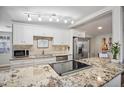 Bright kitchen boasts white cabinetry, stainless steel appliances, and granite countertops at 1159 Stewart Dr, Dunedin, FL 34698