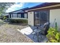 Cozy patio with wicker chair and side table, adjacent to the house at 1311 Powderpuff Dr # 1003, Dunedin, FL 34698