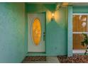 Light teal front door with an oval window and a welcome mat at 13851 102Nd Ave, Largo, FL 33774