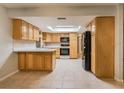 Kitchen with light wood cabinets, tiled floor and black appliances at 13851 102Nd Ave, Largo, FL 33774