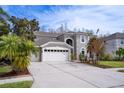 Two-story house with a three-car garage, palm trees, and well-maintained landscaping at 18809 Chaville Rd, Lutz, FL 33558