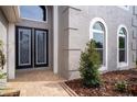 Elegant double-door entry with glass inserts and a stone walkway at 18809 Chaville Rd, Lutz, FL 33558