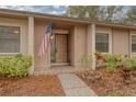 Front entrance of condo, featuring a wooden door and American flag at 20 Sylvia Pl, Oldsmar, FL 34677