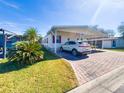 Mobile home with covered carport and landscaping at 3020 Moss Hill St, Wesley Chapel, FL 33543