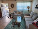 Cozy living room featuring tile floors, neutral couches, and bright window with curtains at 3060 64Th N Ave, St Petersburg, FL 33702