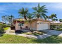 Single story home with a two car garage and palm trees at 4415 Muirfield, Bradenton, FL 34210