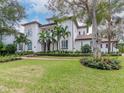 Two-story house with a white facade, brown roof, and lush landscaping at 4818 W San Rafael St, Tampa, FL 33629