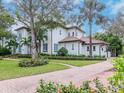 Two-story house with a white facade, brown roof, and lush landscaping at 4818 W San Rafael St, Tampa, FL 33629