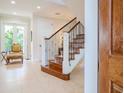 Elegant wooden staircase with wrought iron railing in a bright foyer at 4818 W San Rafael St, Tampa, FL 33629