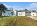 Newly renovated home with gray accents and a landscaped yard at 4918 Cresthill Dr, Tampa, FL 33615